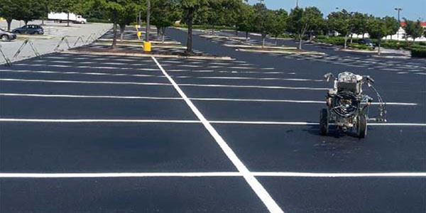 Image of a striping maching and a striped parking lot.